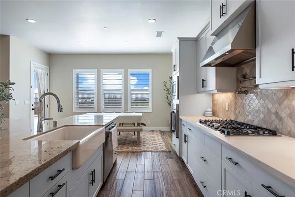 a kitchen with granite countertop a sink stove and cabinets