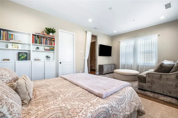 a bedroom with a large bed and a flat screen tv