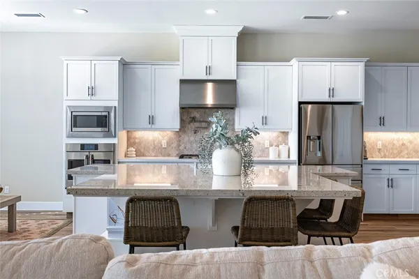a kitchen with kitchen island granite countertop white cabinets and refrigerator