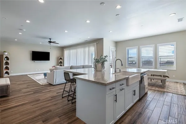 a large kitchen with stainless steel appliances a large center island attached withe living room