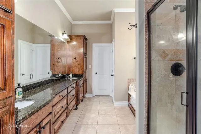 a bathroom with a granite countertop double vanity and a mirror