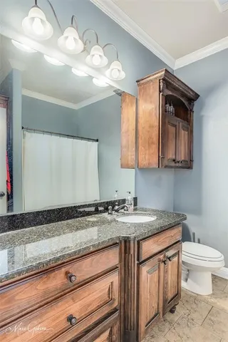 a bathroom with a granite countertop sink a toilet and mirror