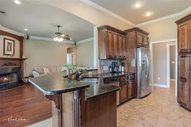 a kitchen with stainless steel appliances granite countertop a sink refrigerator and cabinets