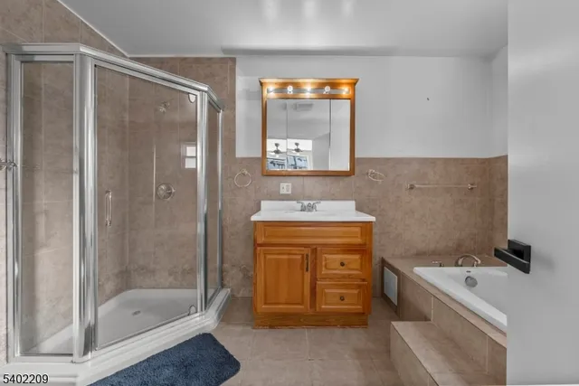 a bathroom with a granite countertop sink a mirror and a bathtub
