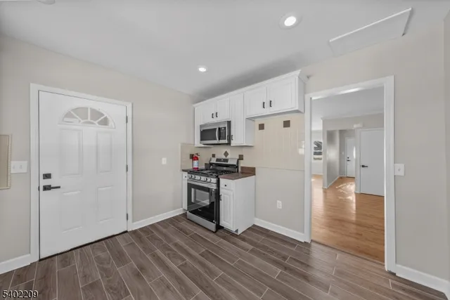 a view of a kitchen with a refrigerator a stove top oven and hallway
