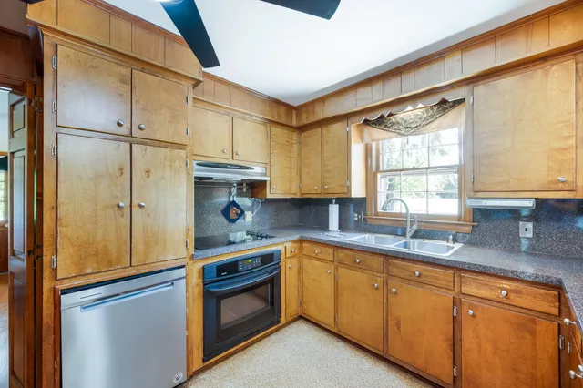 a living room with furniture a flat screen tv and kitchen view