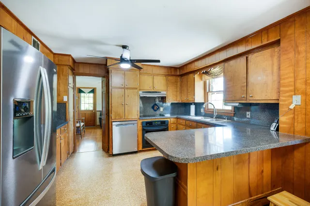 an empty room with wooden floor and ceiling fan