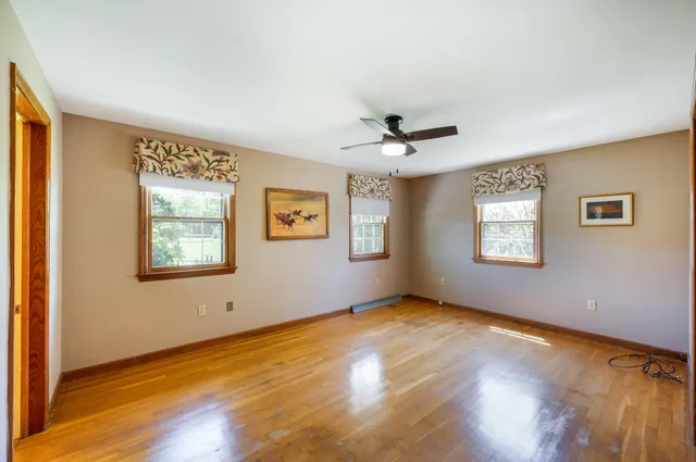 an empty room with a window and a ceiling fan