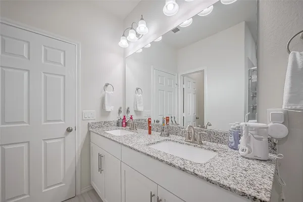 a bathroom with double vanity sinks and a mirror