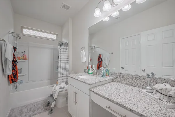 a bathroom with a granite countertop sink a toilet and shower
