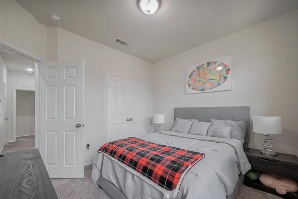 a bedroom with a bed and painting on the wall