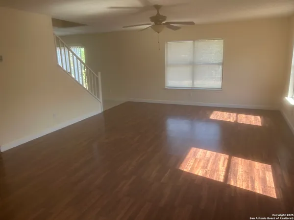 an empty room with wooden floor windows and entrance