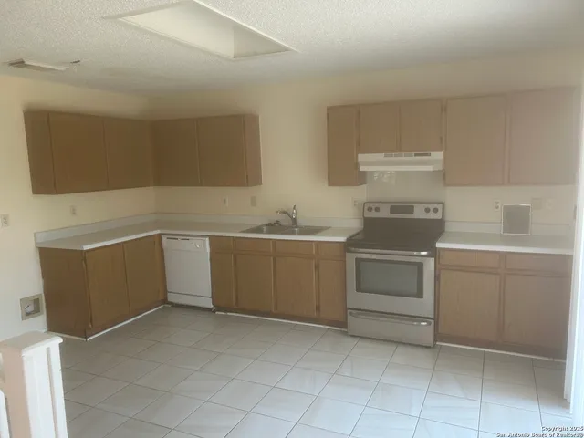a kitchen with a stove sink and cabinets
