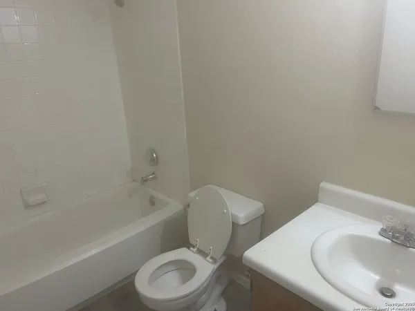 a white toilet sitting next to a bath tub