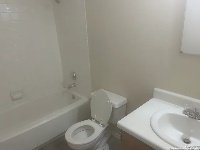a white toilet sitting next to a bath tub