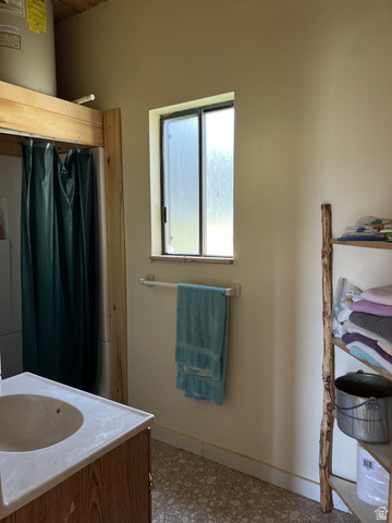 123 Tbd Monroe Canyon Road Monroe, UT 84754 - Photo 11 of 92 Bathroom featuring a wood-finish vanity with an integrated sink, a frosted-pane window, and textured flooring