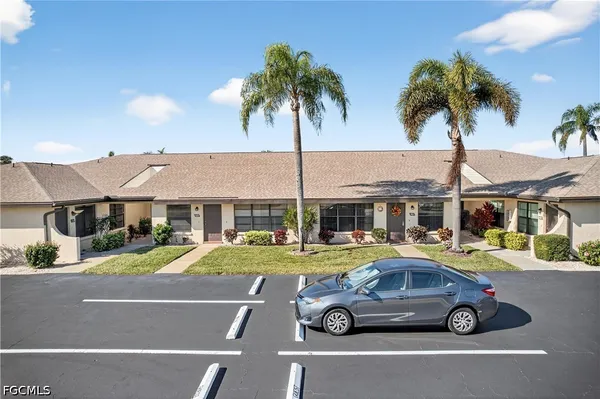 a car parked in front of a house with palm trees