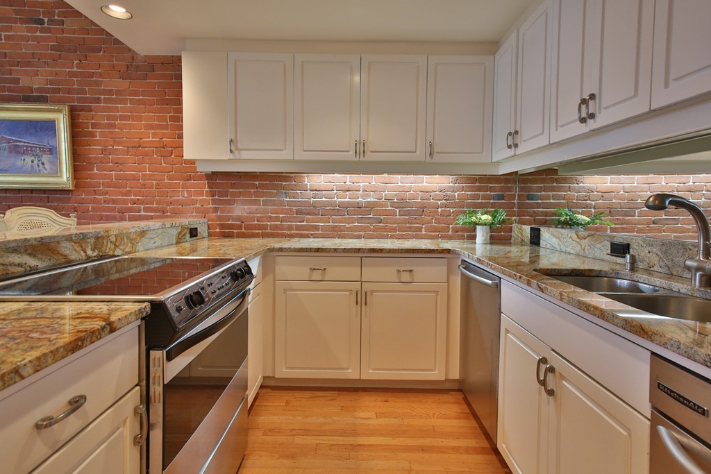 136 Beacon Street, Unit 7 Boston, MA 02116 - Photo 3 of 7 a kitchen with stainless steel appliances granite countertop a sink stove and cabinets