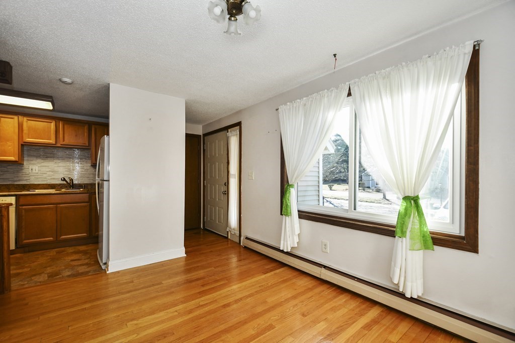164 Ayer Road, Unit H4 Shirley, MA 01464 - Photo 11 of 33 a view of an empty room with a window and wooden floor