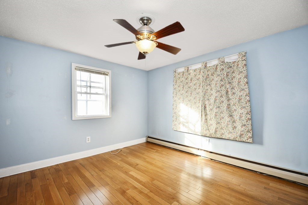 164 Ayer Road, Unit H4 Shirley, MA 01464 - Photo 13 of 33 an empty room with wooden floor fan and windows