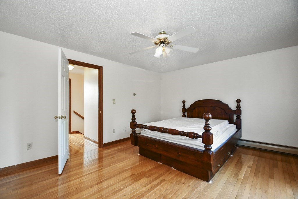 164 Ayer Road, Unit H4 Shirley, MA 01464 - Photo 19 of 33 a bedroom with a bed and wooden floor