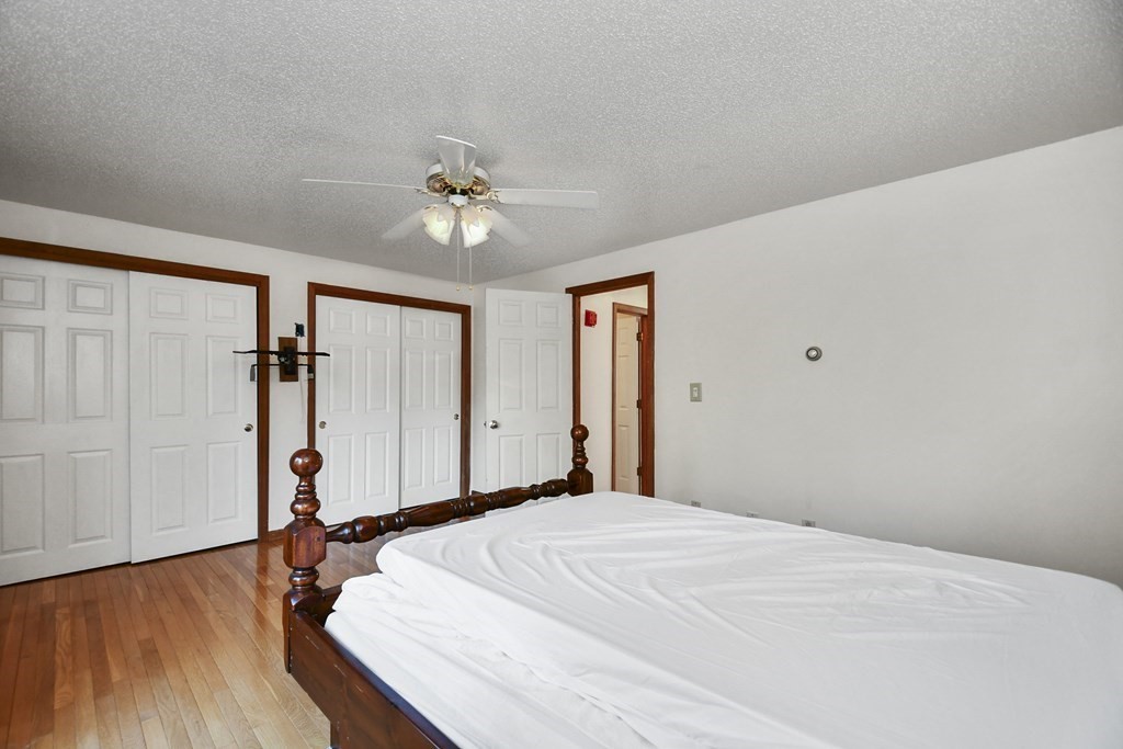 164 Ayer Road, Unit H4 Shirley, MA 01464 - Photo 20 of 33 a bedroom with a bed and wooden floor