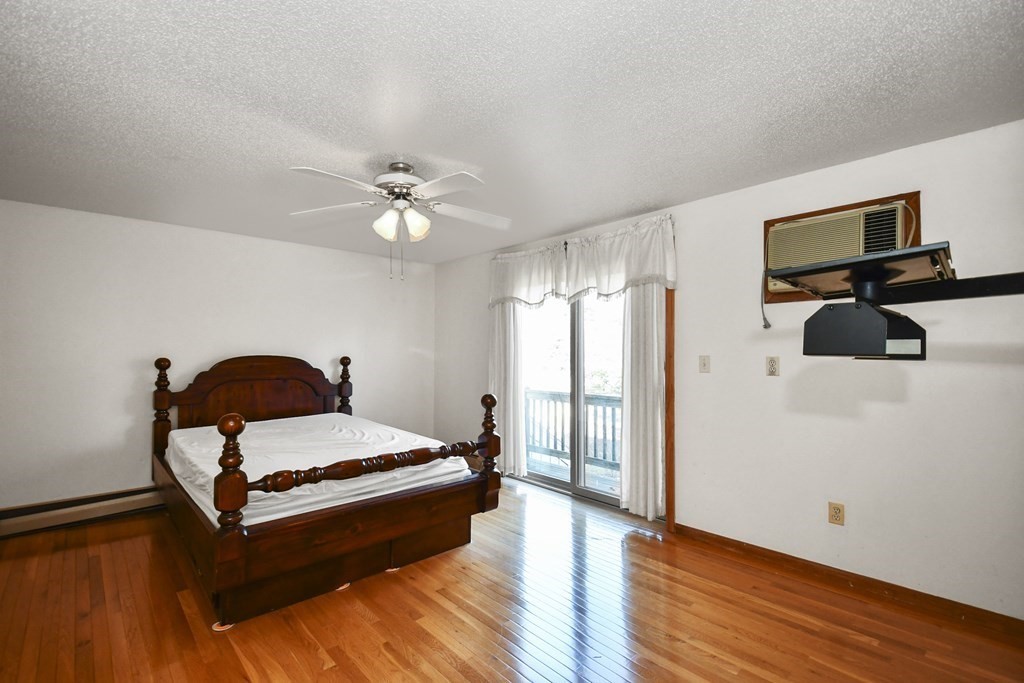 164 Ayer Road, Unit H4 Shirley, MA 01464 - Photo 22 of 33 a bedroom with a bed and wooden floor