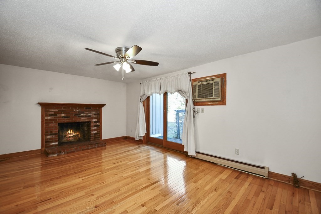 164 Ayer Road, Unit H4 Shirley, MA 01464 - Photo 5 of 33 a view of an empty room with window and wooden floor