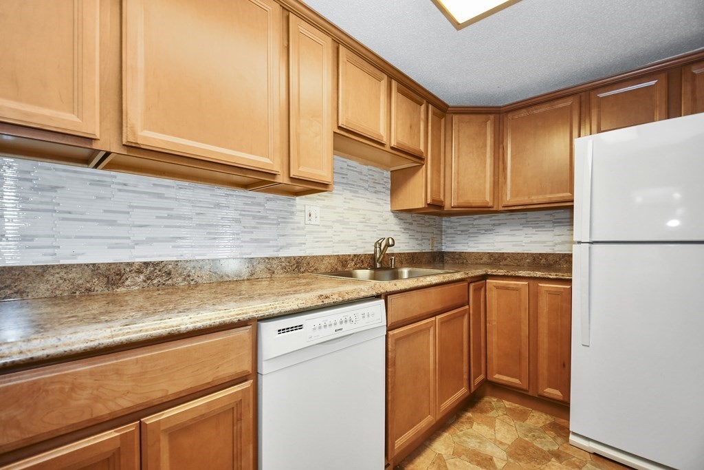 164 Ayer Road, Unit H4 Shirley, MA 01464 - Photo 10 of 33 a kitchen with stainless steel appliances granite countertop a sink and cabinets