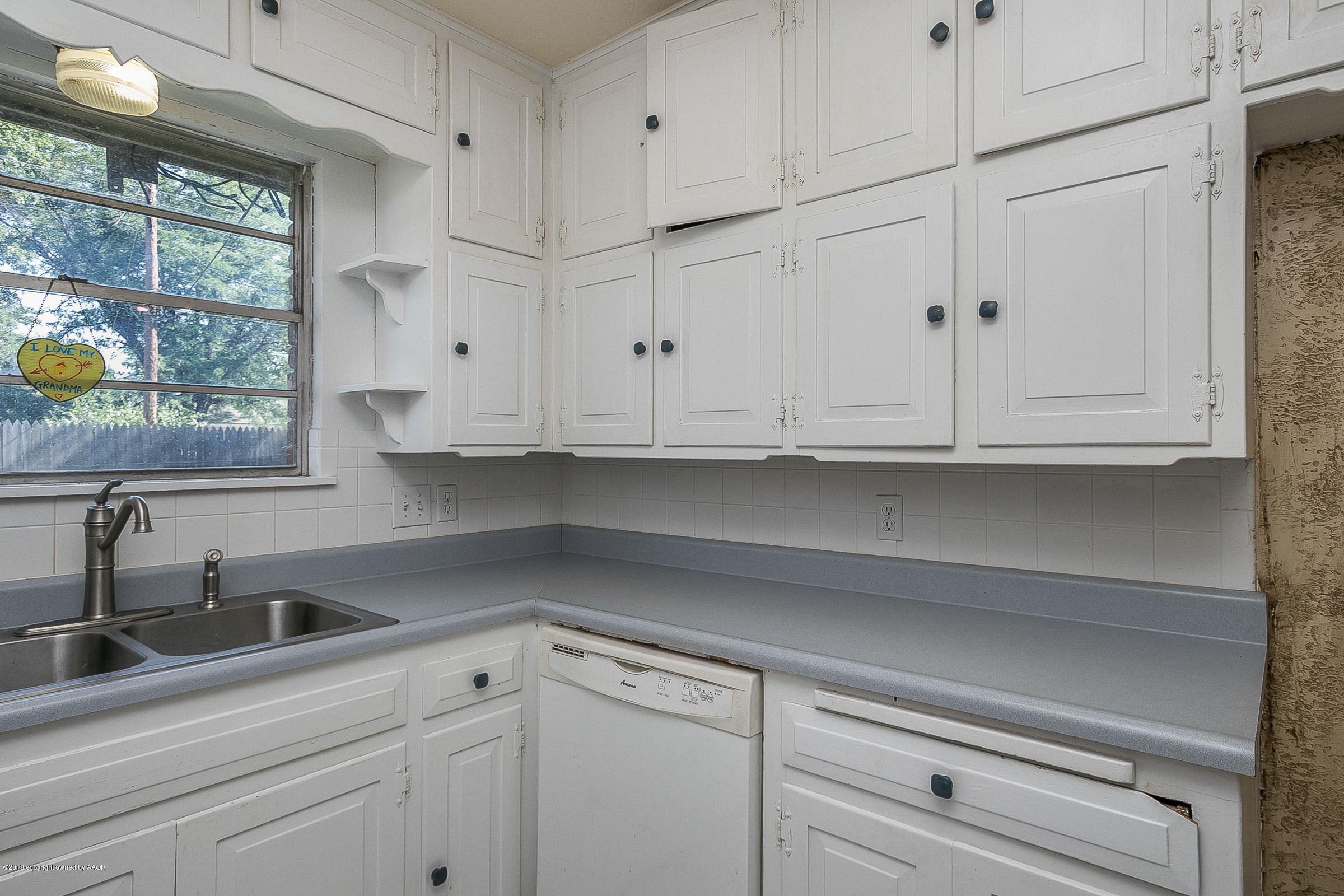 6016 Elmhurst Road Amarillo, TX 79106 - Photo 11 of 21 a kitchen with white cabinets and a sink