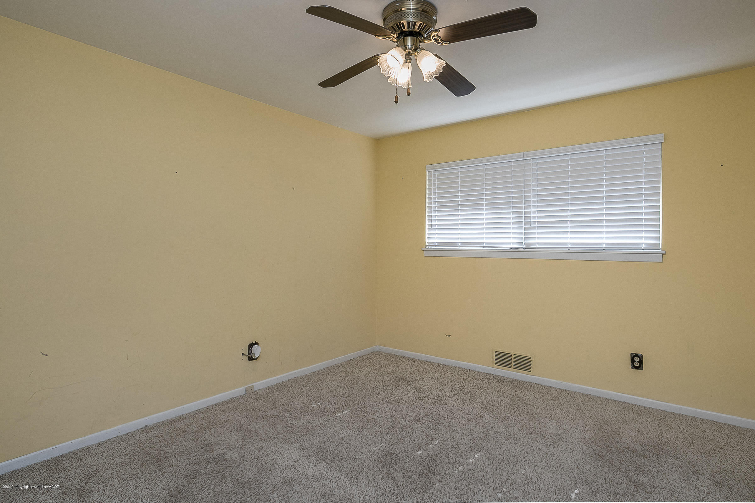 6016 Elmhurst Road Amarillo, TX 79106 - Photo 15 of 21 an empty room with a window and a fan
