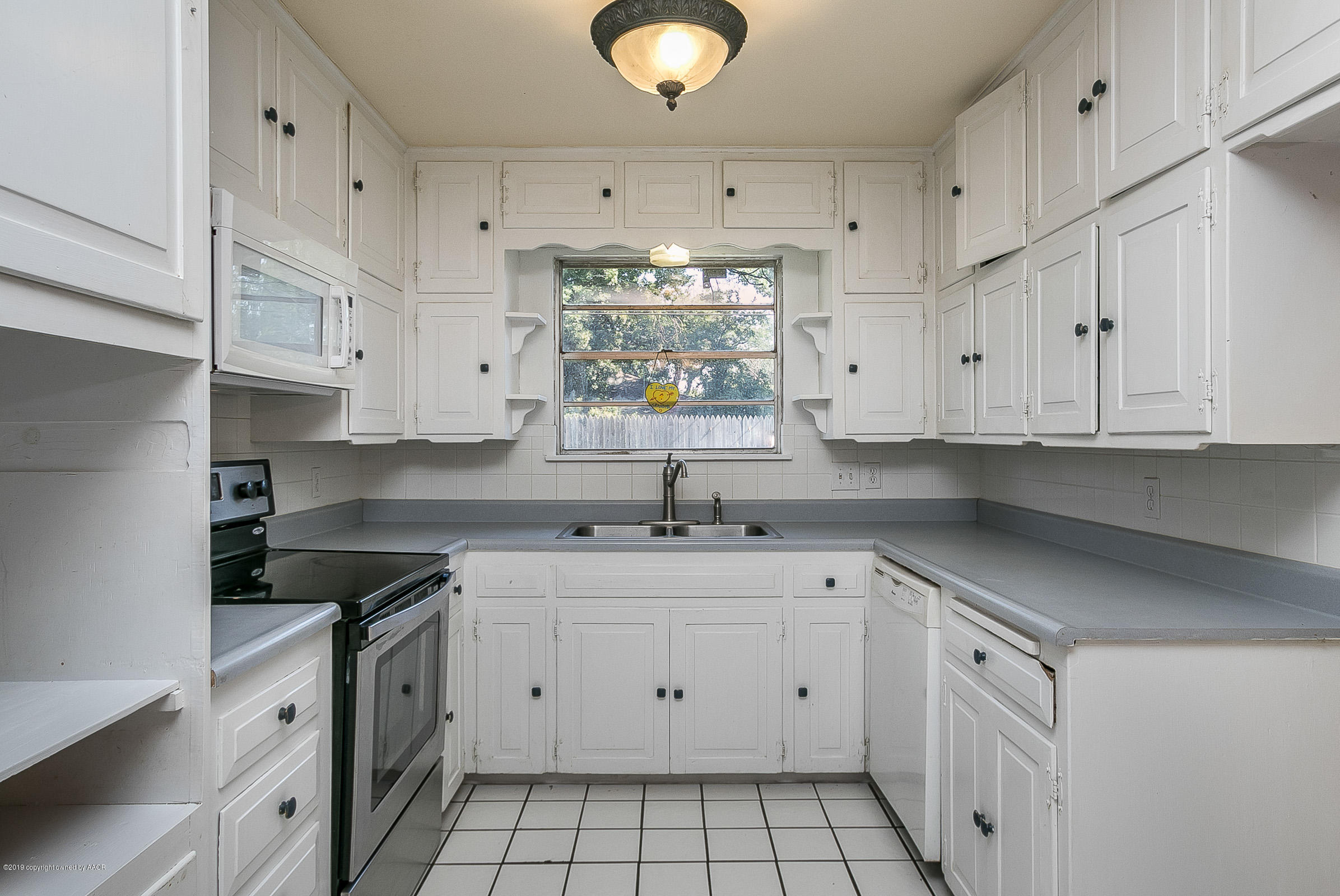 6016 Elmhurst Road Amarillo, TX 79106 - Photo 9 of 21 a kitchen with white cabinets appliances and a sink