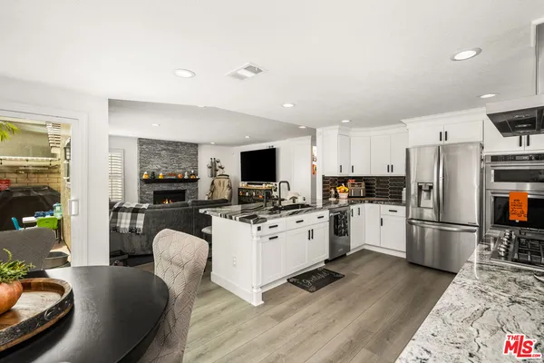 a kitchen with large white cabinets a table and chairs