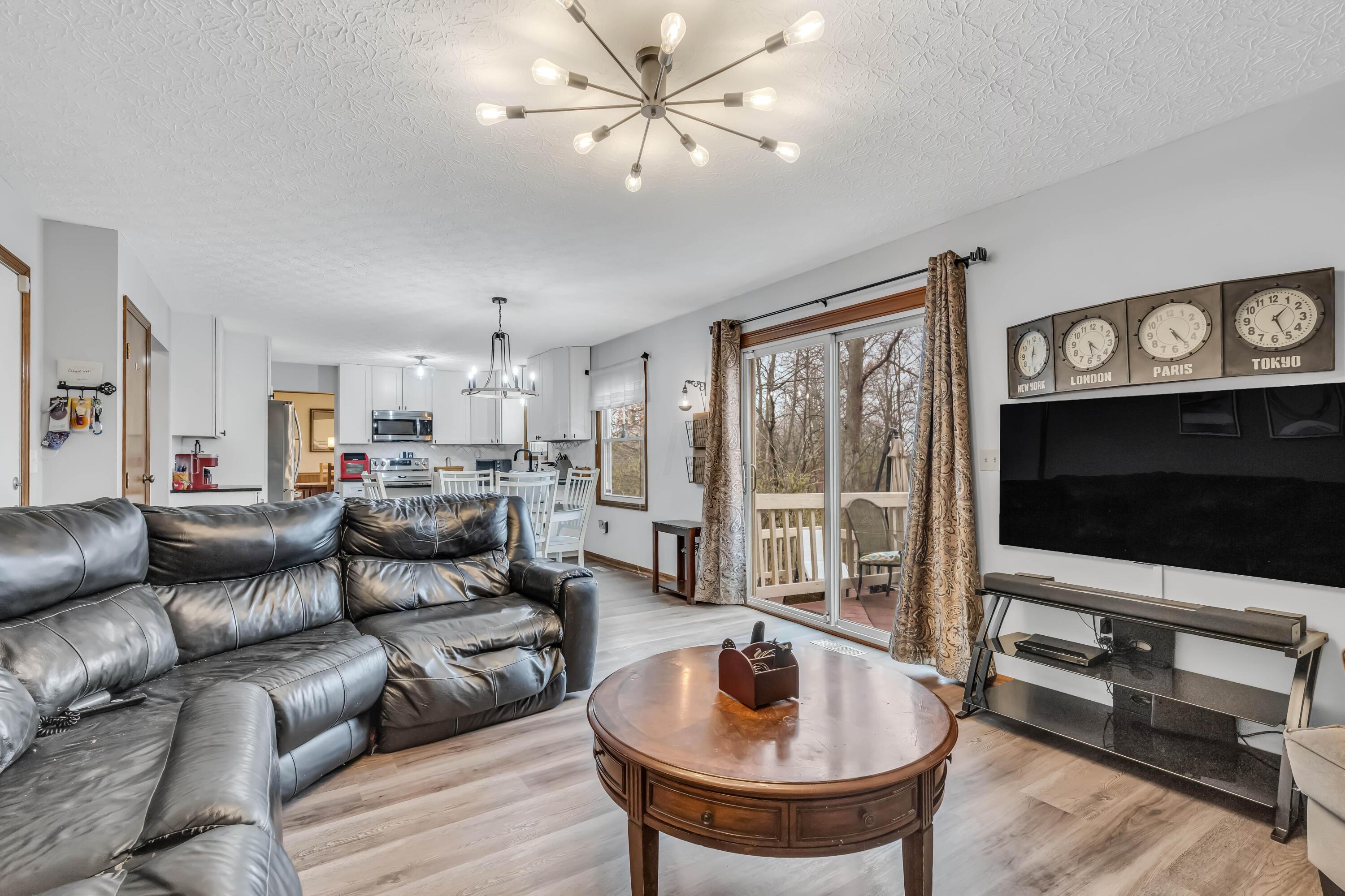 435 Emory Street Gahanna, OH 43230 - Photo 22 of 54 • New luxury vinyl plank
flooring ~ 2022
• Pale grey painted walls
• Woodburning brick fireplace
with mantle & raised
hearth
• Double sliding doors to
deck
• New ceiling light
• Drapes remain