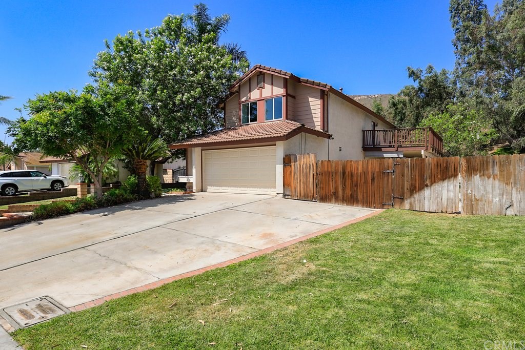 a front view of a house with a yard and trees