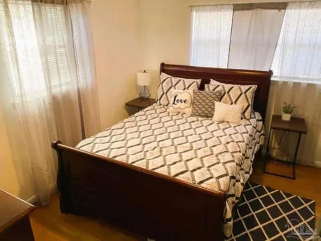 a large bed sitting in a bedroom next to a window