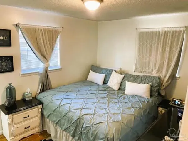 a bedroom with a bed and a flat tv screen on the dresser