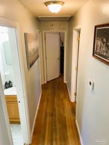 a view of a hallway with wooden floor and stairs