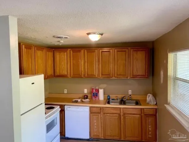a kitchen with stainless steel appliances granite countertop a sink stove and cabinets