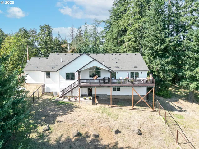 an aerial view of a house with wooden deck and a big yard