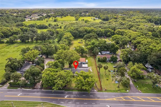 an aerial view of residential houses with outdoor space and trees