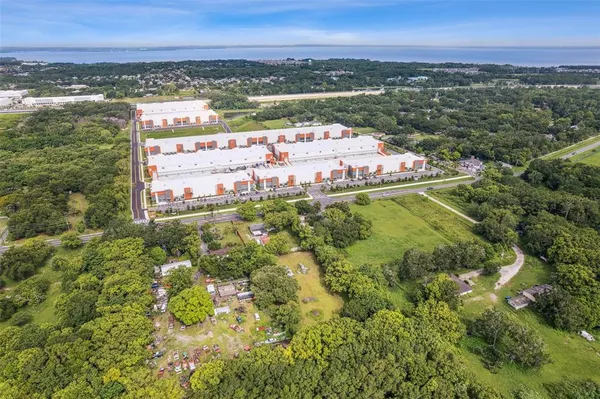 an aerial view of residential houses with outdoor space and trees