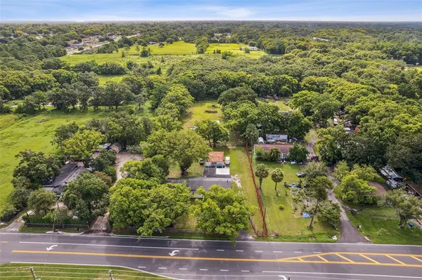 an aerial view of residential houses with outdoor space and trees