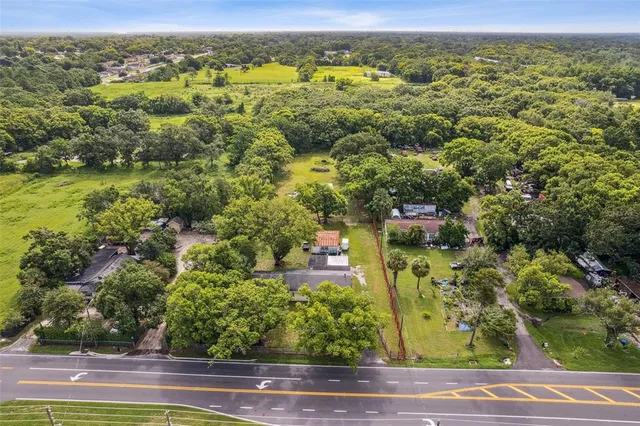 an aerial view of residential houses with outdoor space and trees