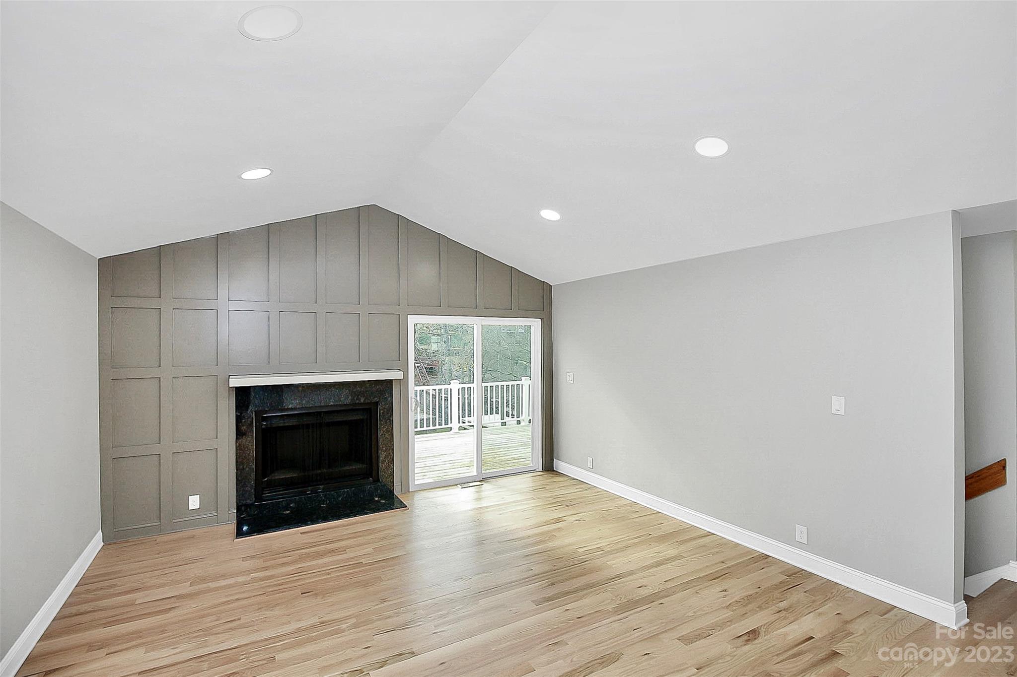 7022 Chelsea Day Lane Tega Cay, SC 29708 - Photo 14 of 48 an empty room with wooden floor fireplace and windows