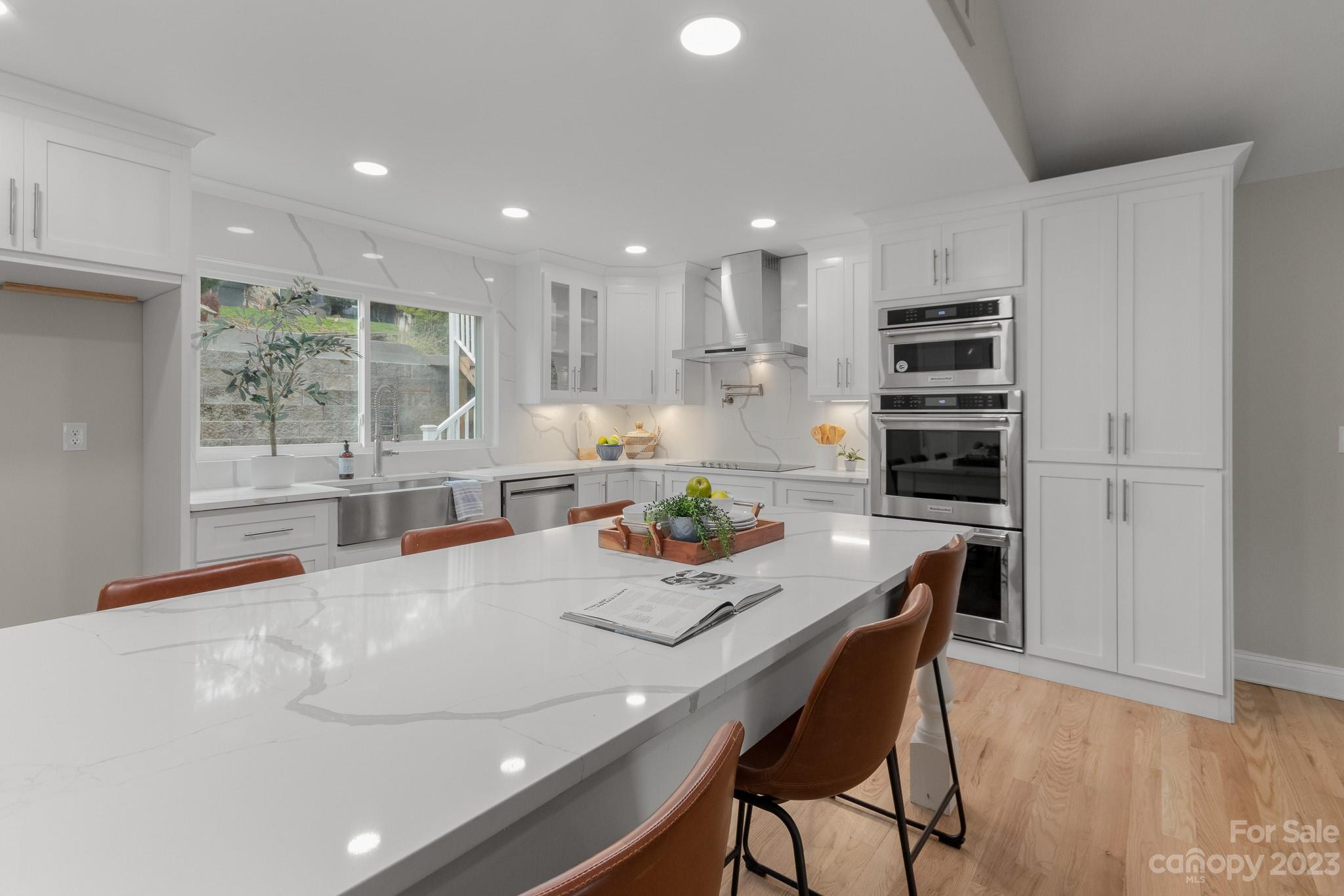 7022 Chelsea Day Lane Tega Cay, SC 29708 - Photo 2 of 48 a kitchen with stainless steel appliances a dining table chairs and wooden floor