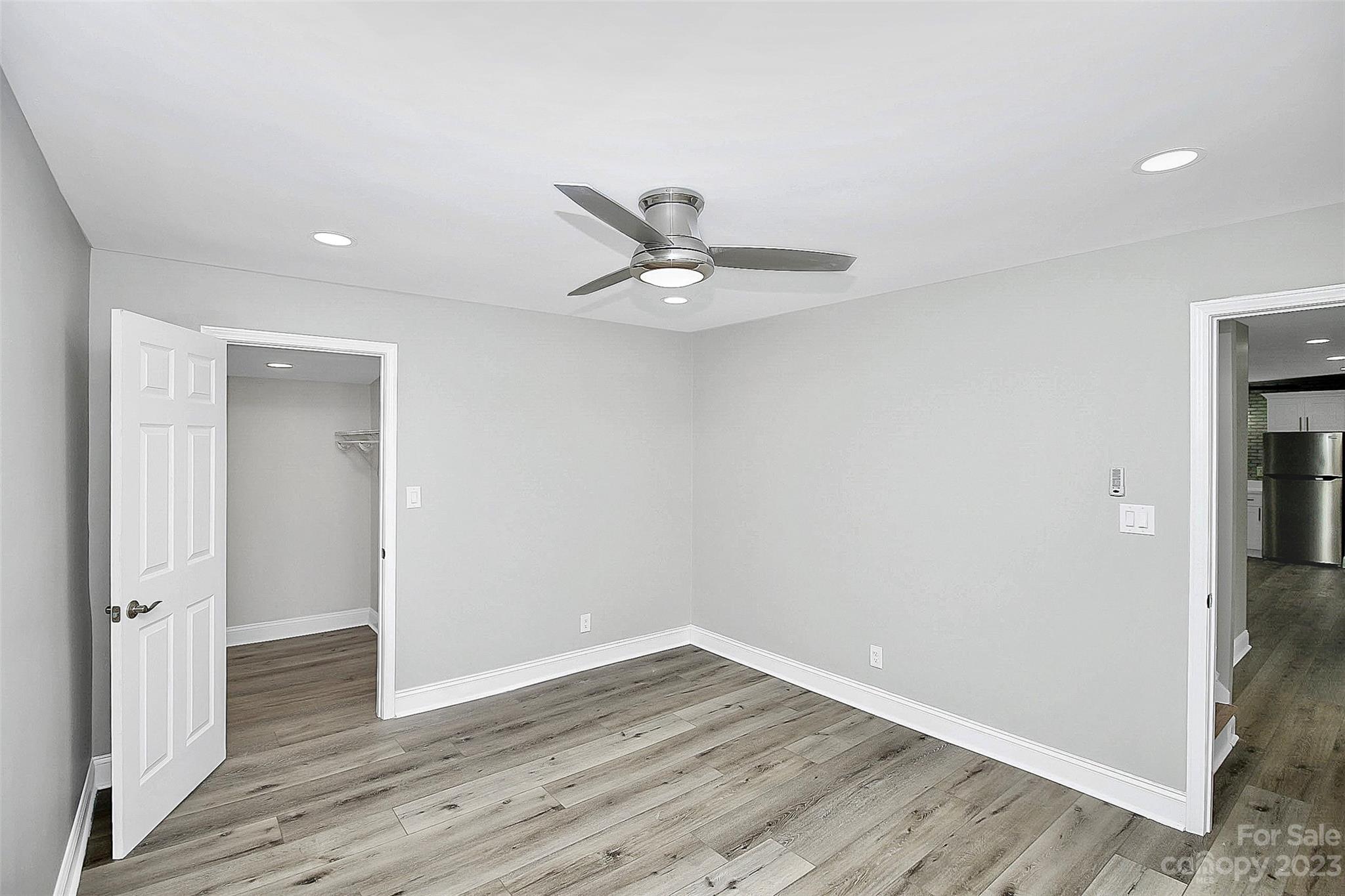 7022 Chelsea Day Lane Tega Cay, SC 29708 - Photo 33 of 48 an empty room with wooden floor and a ceiling fan