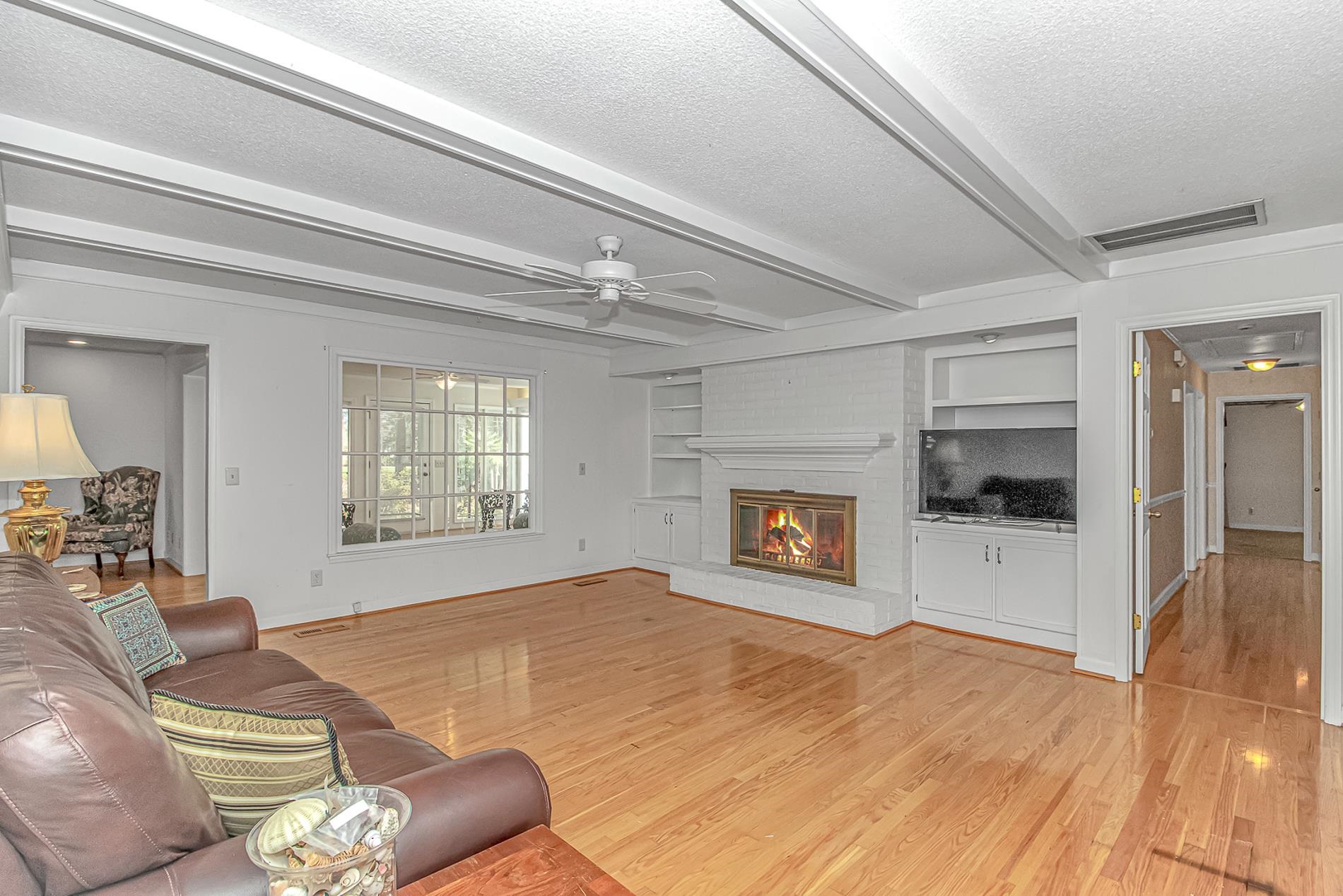 119 University Circle Conway, SC 29526 - Photo 13 of 40 Living area with built in shelves, a textured ceiling, beam ceiling, a fireplace, and light wood-type flooring