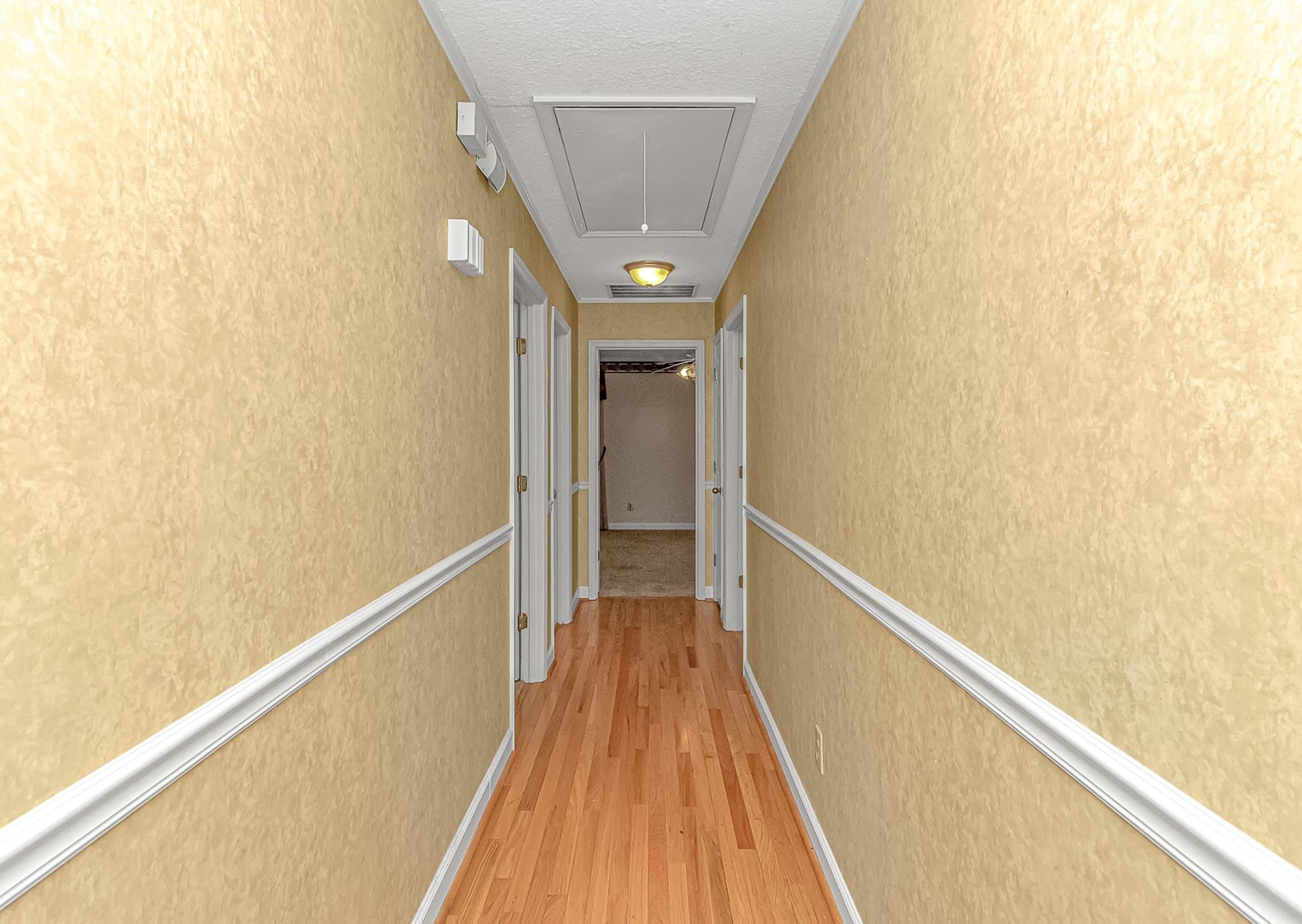 119 University Circle Conway, SC 29526 - Photo 21 of 40 Hall with attic access, light wood-type flooring, a textured ceiling, and a textured wall