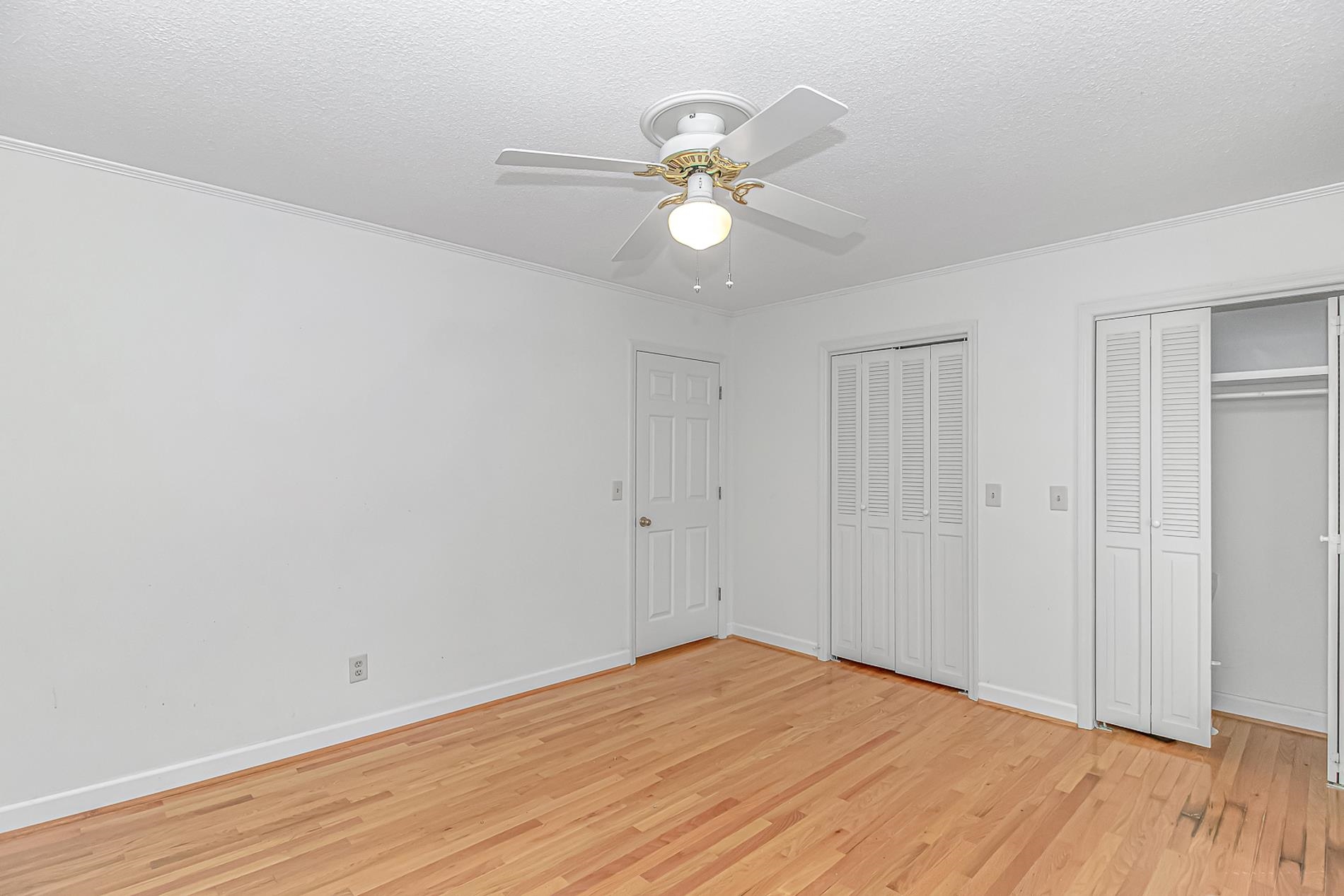 119 University Circle Conway, SC 29526 - Photo 23 of 40 Unfurnished bedroom featuring multiple closets, light wood-type flooring, ceiling fan, a textured ceiling, and ornamental molding